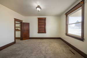 Carpeted spare room with a textured ceiling