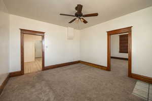 Carpeted empty room featuring ceiling fan