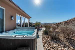 View of pool with a hot tub and a mountain view