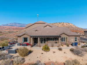 Back of house featuring a mountain view, a patio, and an outdoor living space with a fire pit