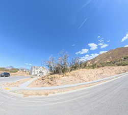 View of asphalt street with a mountain view, curbs, and sidewalks