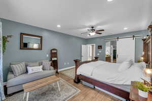 Bedroom featuring ceiling fan and a barn door