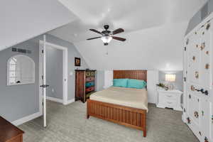 Carpeted bedroom with lofted ceiling and ceiling fan