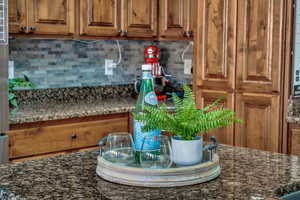 Kitchen with dark stone counters and decorative backsplash