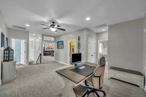 Office space with light carpet and ceiling fan