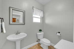 Bathroom featuring sink, toilet, and tile patterned flooring