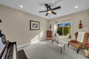 Living room with carpet floors and ceiling fan