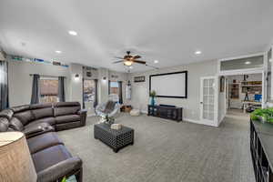 Carpeted living room with ceiling fan