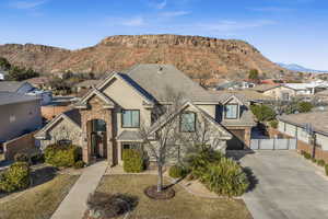 View of front of house with a garage, a mountain view, and a front yard