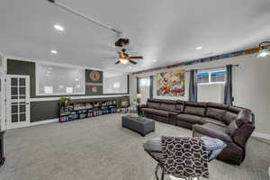 Carpeted living room featuring ceiling fan