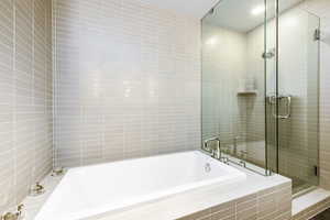 Bathroom featuring shower with separate bathtub