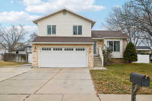 View of front of house featuring a garage and a front lawn