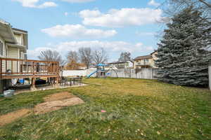 View of yard featuring a playground, a deck, and a patio area