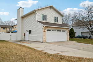 View of side of property featuring a yard and a garage