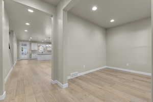 Spare room with a chandelier and light hardwood / wood-style floors