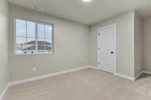 Unfurnished room featuring light carpet