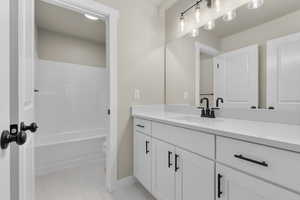 Full bathroom with vanity, tub / shower combination, tile patterned floors, and toilet