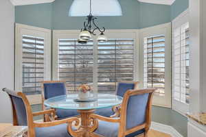 Dining space featuring vaulted ceiling, a healthy amount of sunlight, and an inviting chandelier