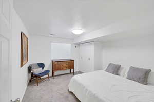 Bedroom featuring light carpet and a closet