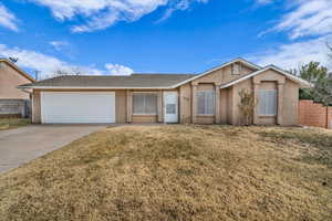 Single story home featuring a garage and a front lawn