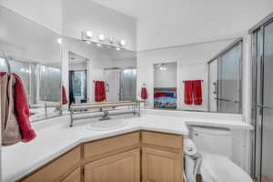 Bathroom featuring vanity, ceiling fan, toilet, and walk in shower