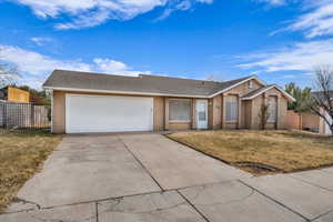 Single story home featuring a garage and a front lawn