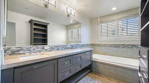 Bathroom featuring vanity and tiled tub