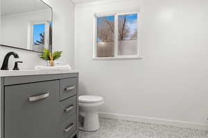 Bathroom with vanity, tile patterned flooring, crown molding, and toilet