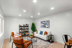 Living room with light hardwood / wood-style flooring, ornamental molding, and a textured ceiling