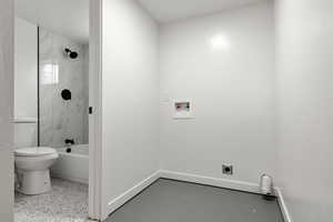 Bathroom featuring toilet and tiled shower / bath combo