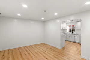 Empty room featuring sink and light wood-type flooring