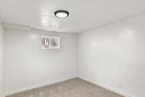 Carpeted empty room with a textured ceiling