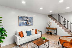 Living room featuring ornamental molding and light wood-type flooring