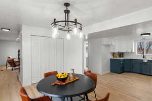 Dining room with crown molding, sink, a textured ceiling, and light wood-type flooring