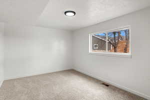 Carpeted empty room with a textured ceiling