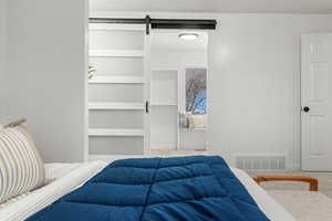 Carpeted bedroom with a barn door