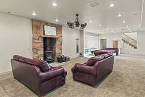 Living room with a wood stove and carpet flooring