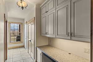 Interior space featuring light tile patterned floors and gray cabinetry