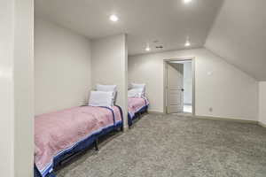 Bedroom with lofted ceiling and carpet