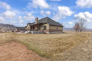 View of side of property featuring a yard, a mountain view, and a patio area