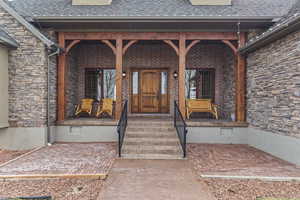 View of exterior entry featuring covered porch