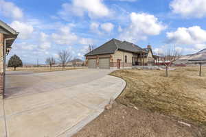 View of home's exterior with a garage and a lawn