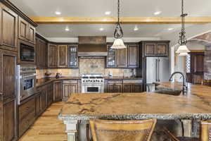 Kitchen featuring high end appliances, a breakfast bar, sink, and pendant lighting