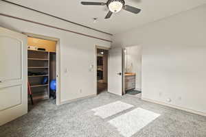 Unfurnished bedroom with ceiling fan, a spacious closet, light colored carpet, and a closet