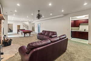 Living room featuring sink, light carpet, and pool table