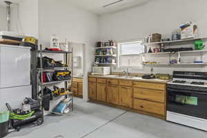 Kitchen featuring gas range, decorative light fixtures, and sink