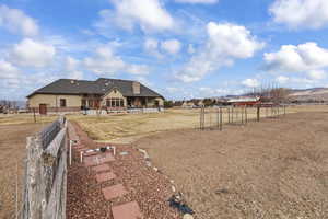 Back of house with a mountain view, a yard, and a patio