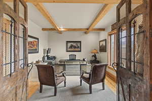 Home office featuring plenty of natural light, beam ceiling, and light wood-type flooring