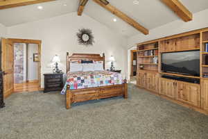 Bedroom with carpet flooring and vaulted ceiling with beams