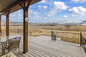 Wooden terrace featuring a mountain view and a rural view